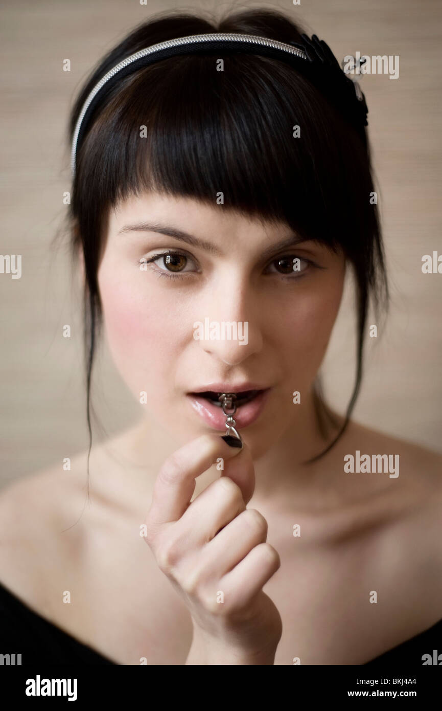 portrait of a young attractive woman with zipper in lips Stock Photo