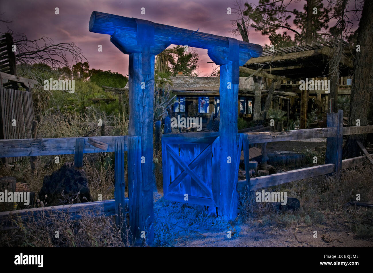 The gate to a creepy old house, painted blue using the "Painting with Light" method at night. Stock Photo