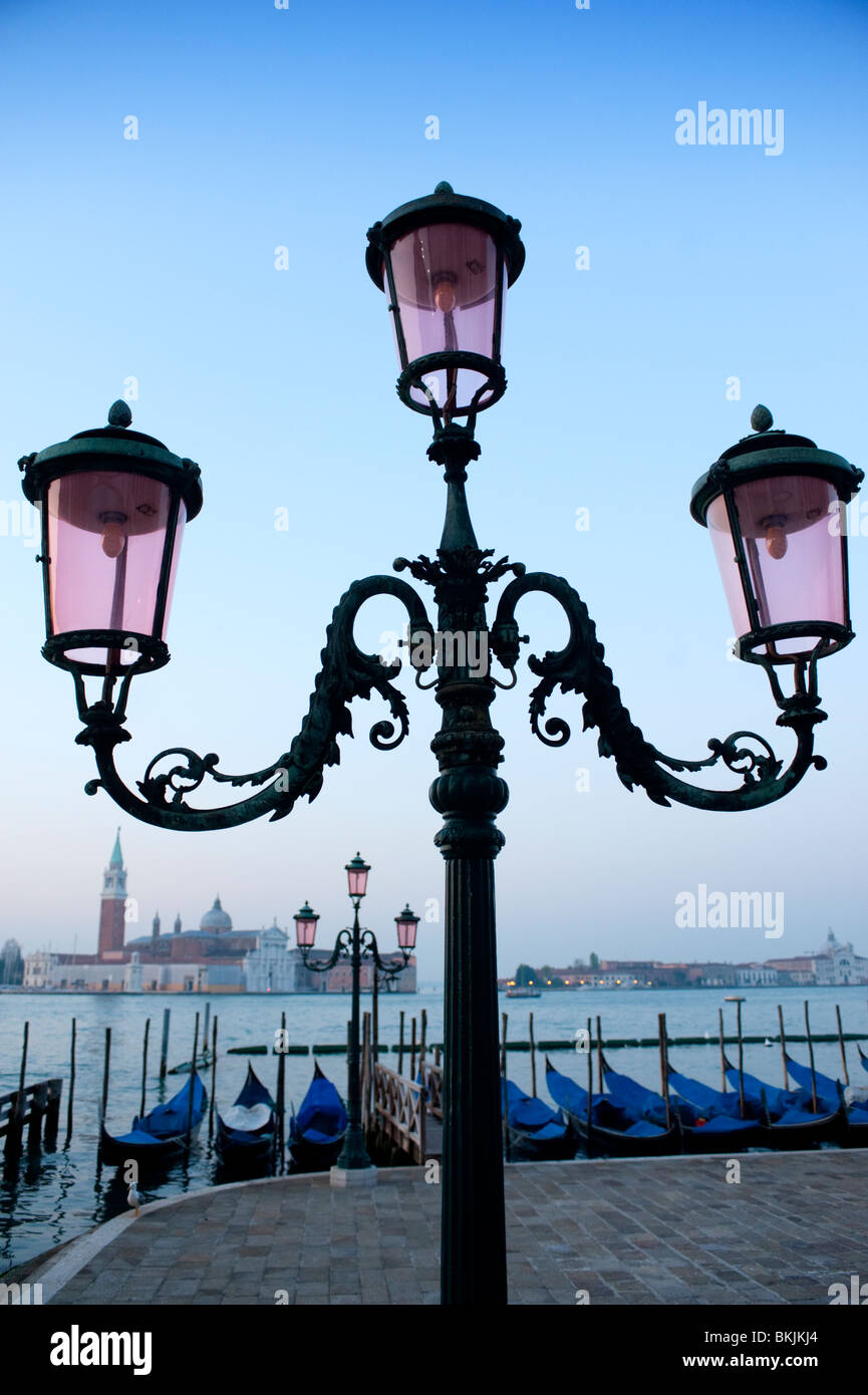 Ornate lamps and gondolas moored at San Marco before dawn in Venice Italy Stock Photo