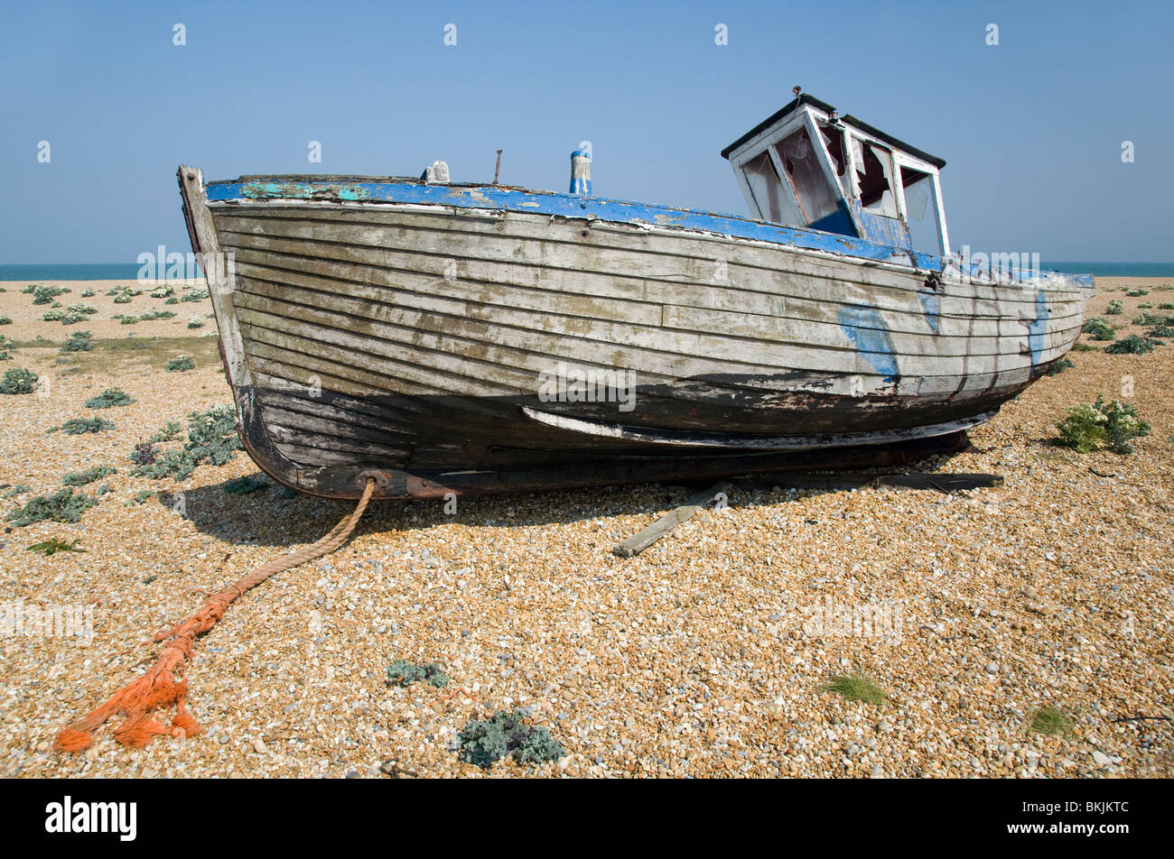 abandoned wrecked fishing boat and engines on the shingle beach in ...