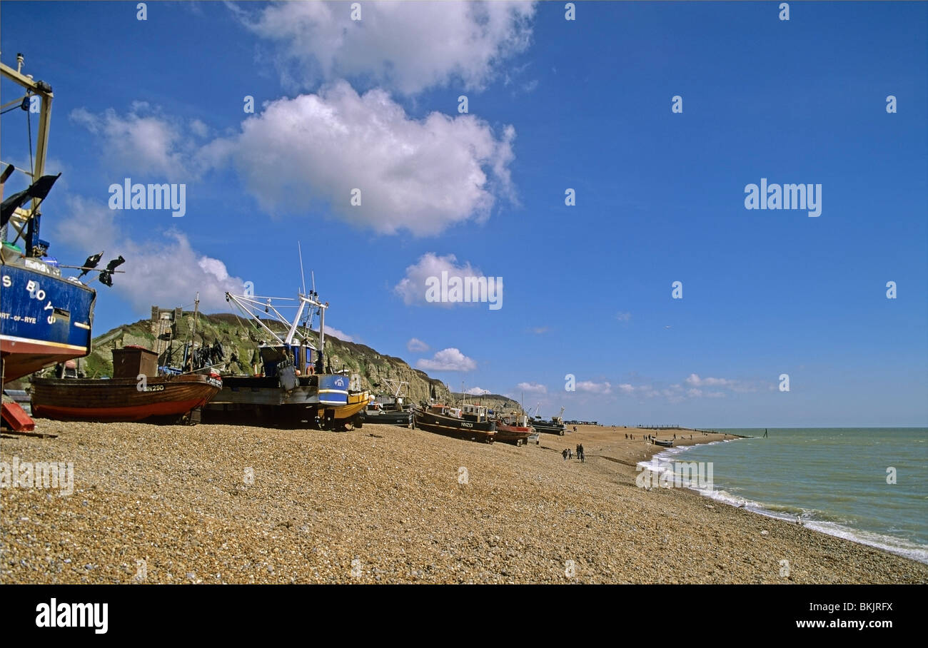 Fishing boats on the steeply sloping shingle beach of The Stade at Hastings towards East Cliff Stock Photo