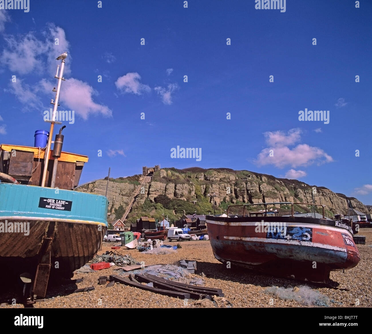 Fishing boats high on the shingle beach area of Hastings East Sussex Stock Photo
