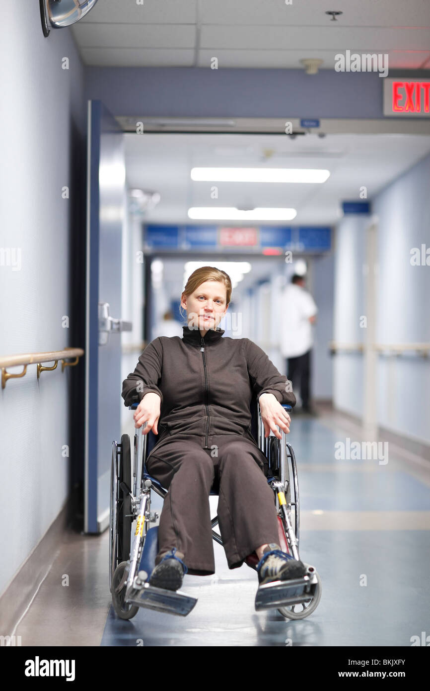 Woman in wheelchair in a hospital hallway. Stock Photo