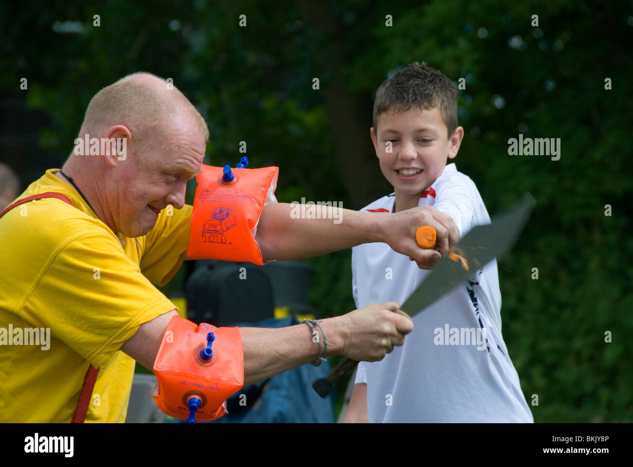 Street entertainer with a child volunteer, Ashton under Lyne, Tameside, Greater Manchester, England, UK Stock Photo