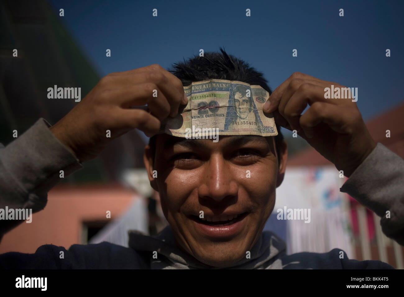 An undocumented Central American migrant jokes around showing a 20 Quetzales bill(Guatemalan currency) in Mexico City Stock Photo