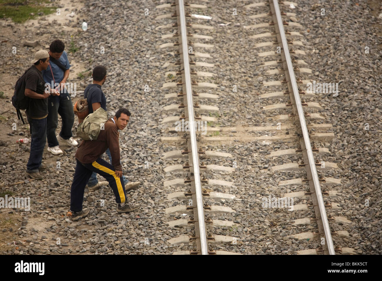Undocumented Central American migrants traveling  to work in the United States wait along the railroad tracks in Mexico City. Stock Photo