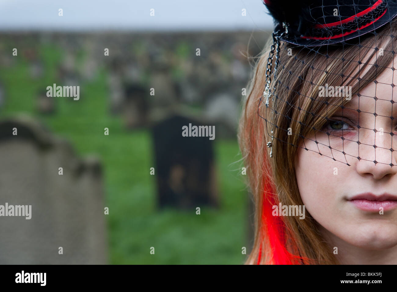 The Face of a Girl in Graveyard with red hair extensions, at Goth Festival Whitby North Yorkshire, UK,  2010 Stock Photo