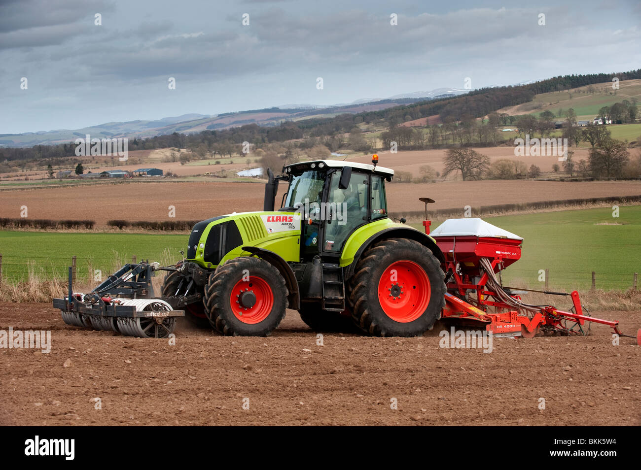 Claas Axion 810 tractor with seed drill and press on and top soil blowing  Stock Photo - Alamy