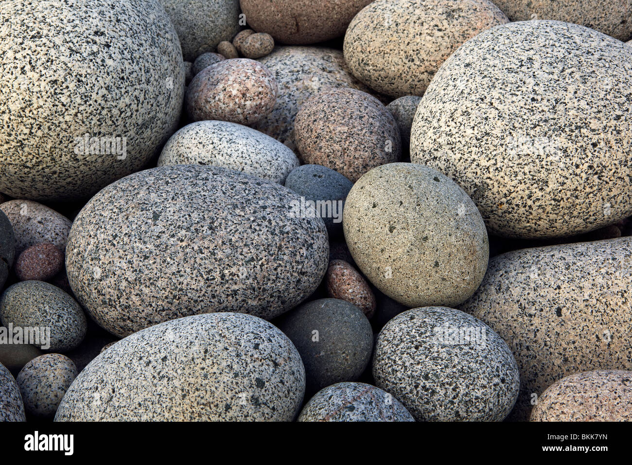 A photograph of smooth round granite rocks on a beach Stock Photo Alamy