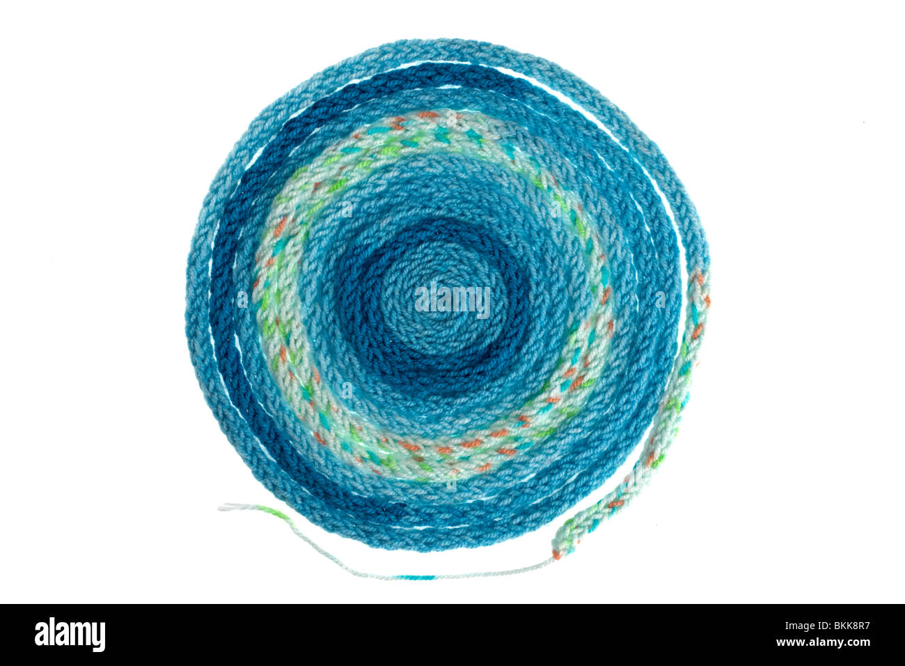 Long coiled thin circular piece of knitted blue wool Stock Photo