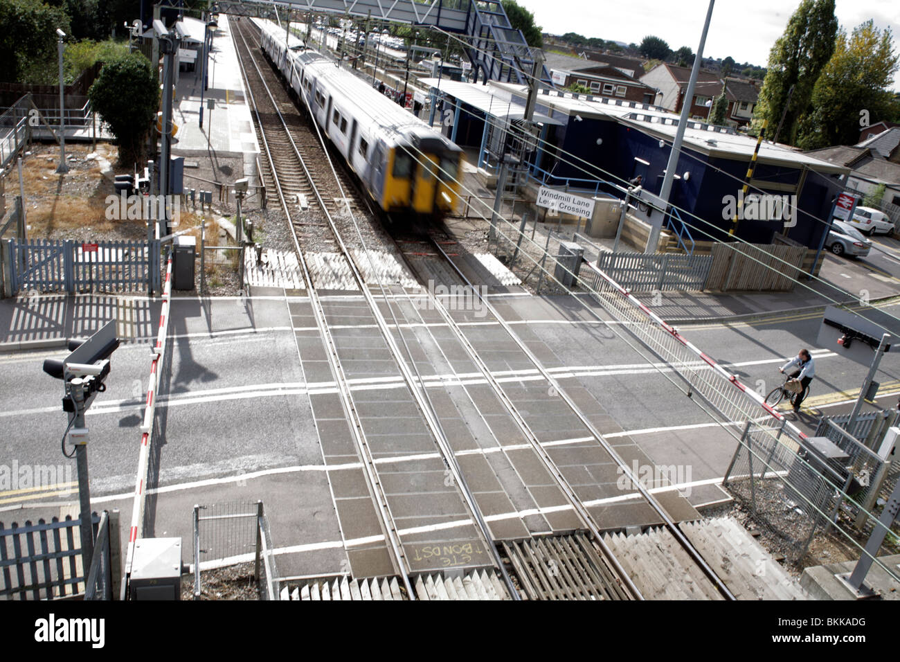 Commuter train entering a level crossing at speed Stock Photo