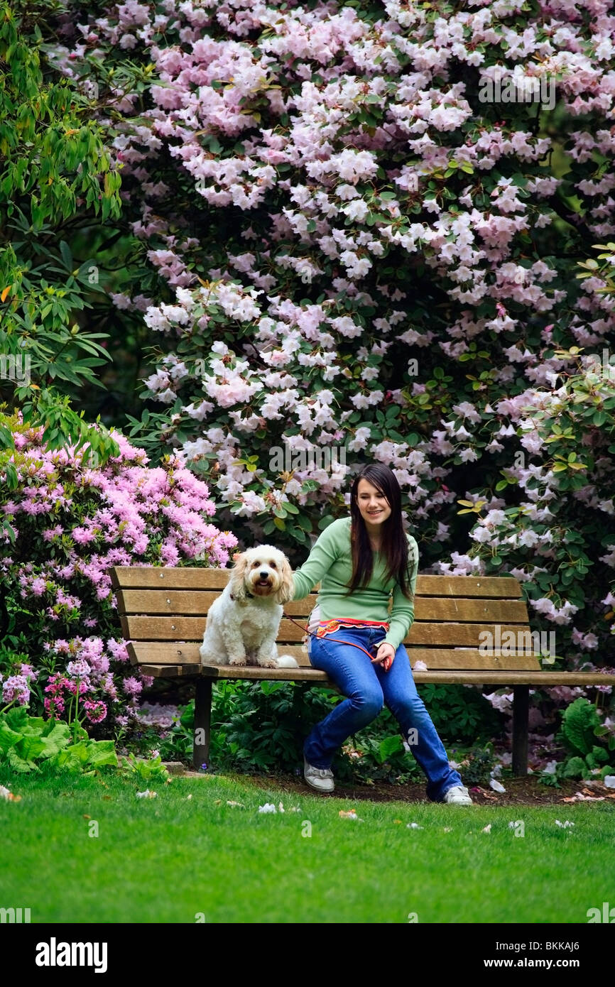 A Girl Sitting With Her Dog On A Bench In The Park Stock Photo - Alamy