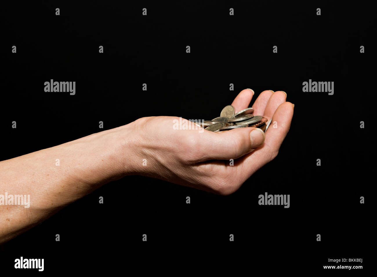 Caucasian male (42 yrs old) with hand held out full of money against a black background Stock Photo