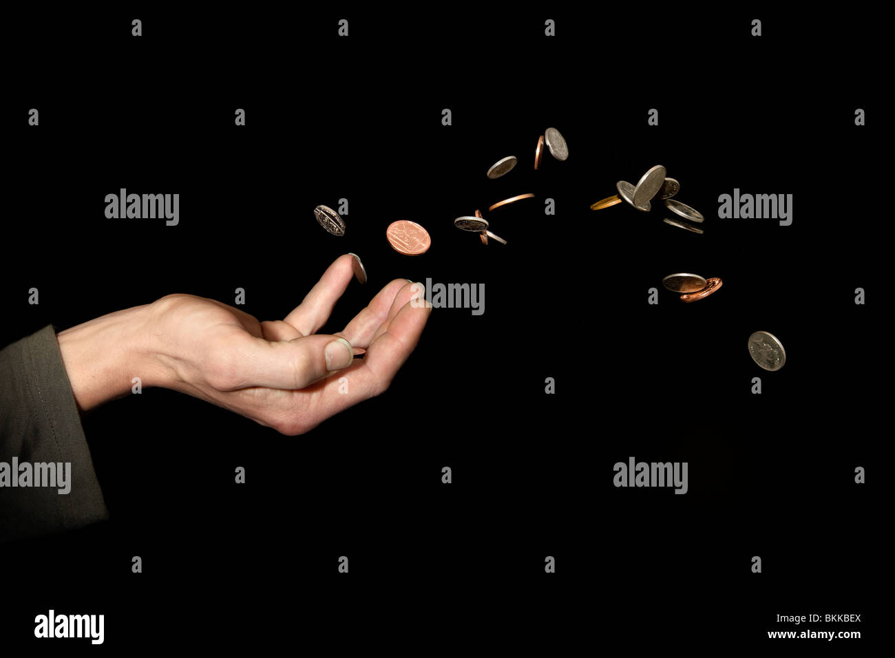 Caucasian male (42 yrs old) hand with money in the air depicting the concept of ‘throwing money away’ Stock Photo