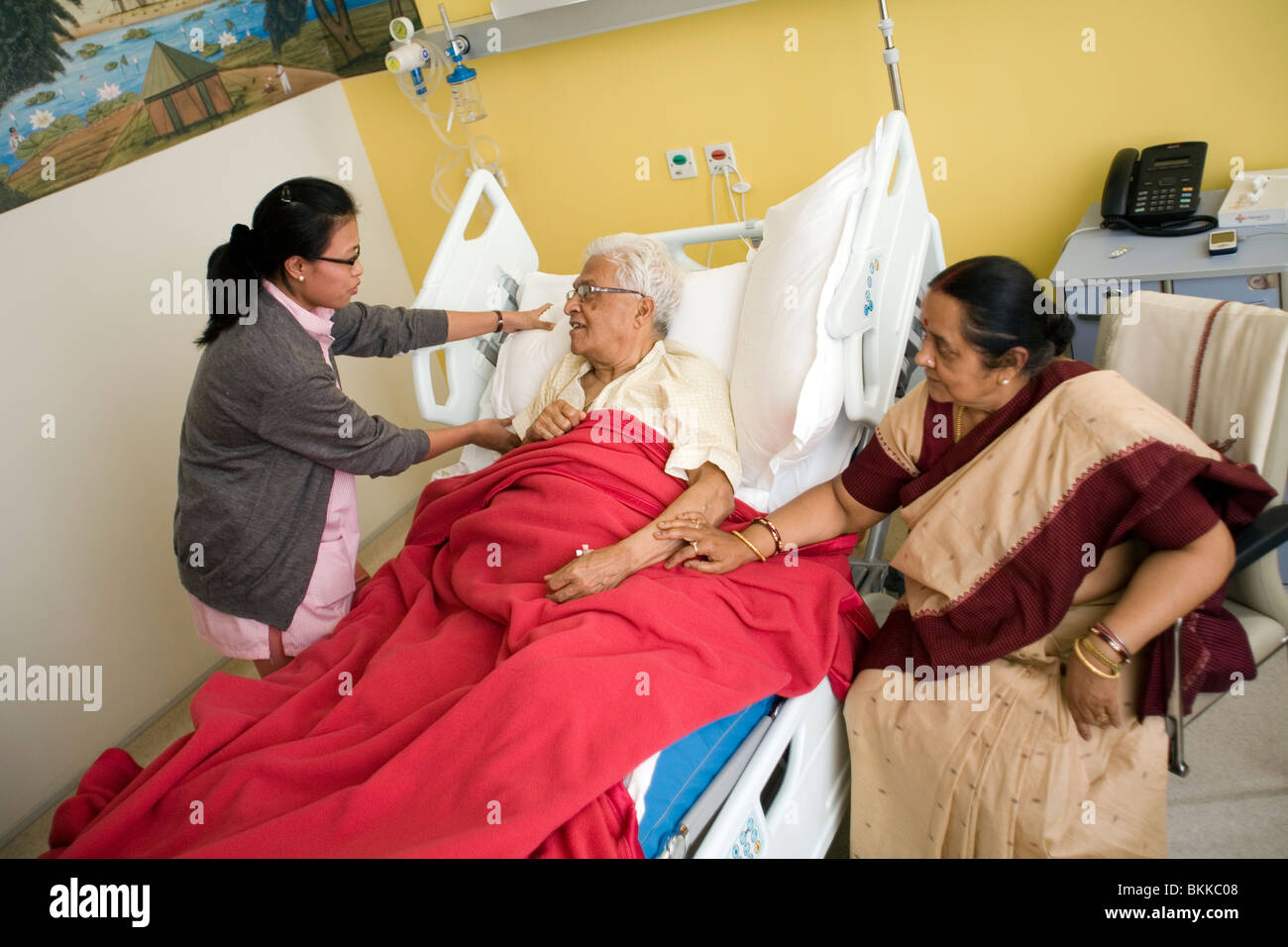 A nurse makes a patient comfortable in bed at the Medicity Hospital, Gurgaon Stock Photo