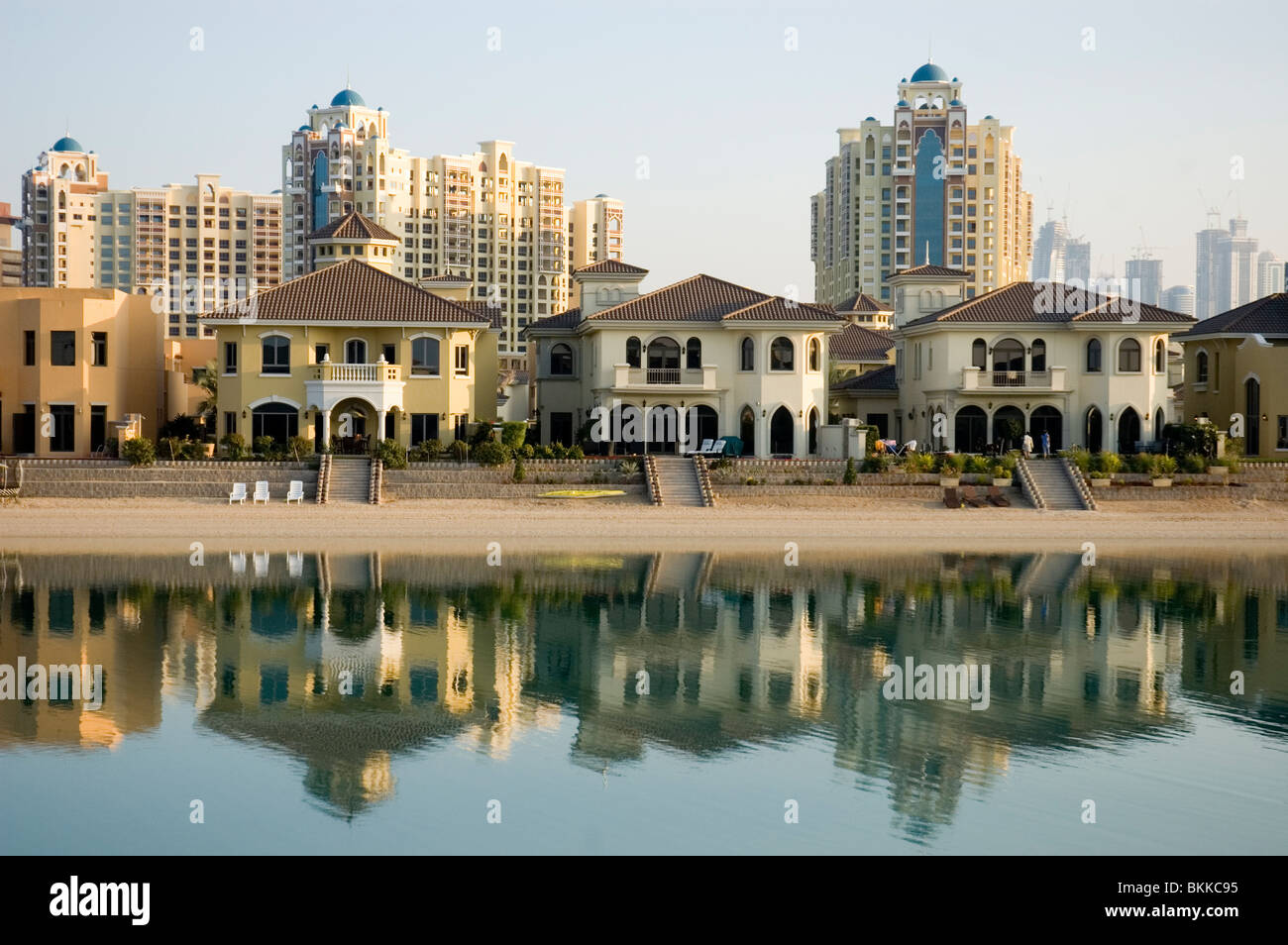 A view of houses on a frond of the Palm Jumeirah in Dubai with apartment blocks and the city of Dubai in the background Stock Photo
