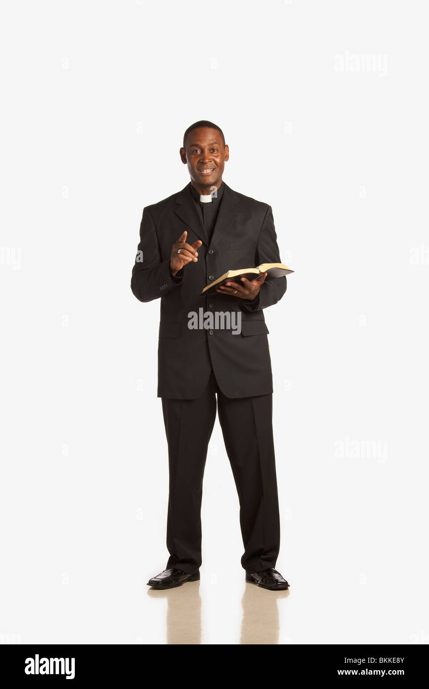 A Man Wearing A Clerical Collar And Preaching From The Bible Stock Photo