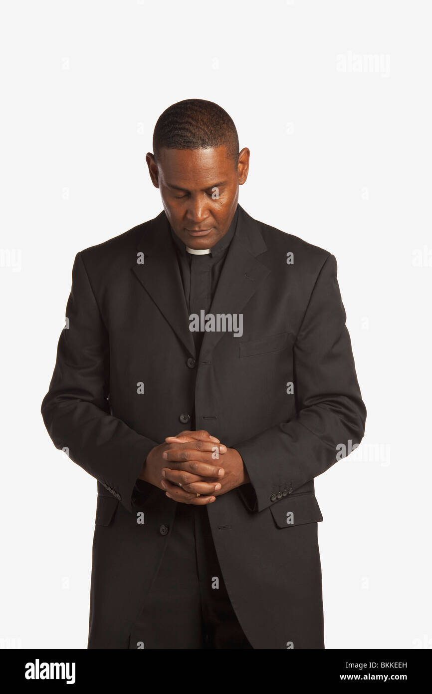 A Man Wearing A Clerical Collar With His Head Bowed In Prayer Stock Photo