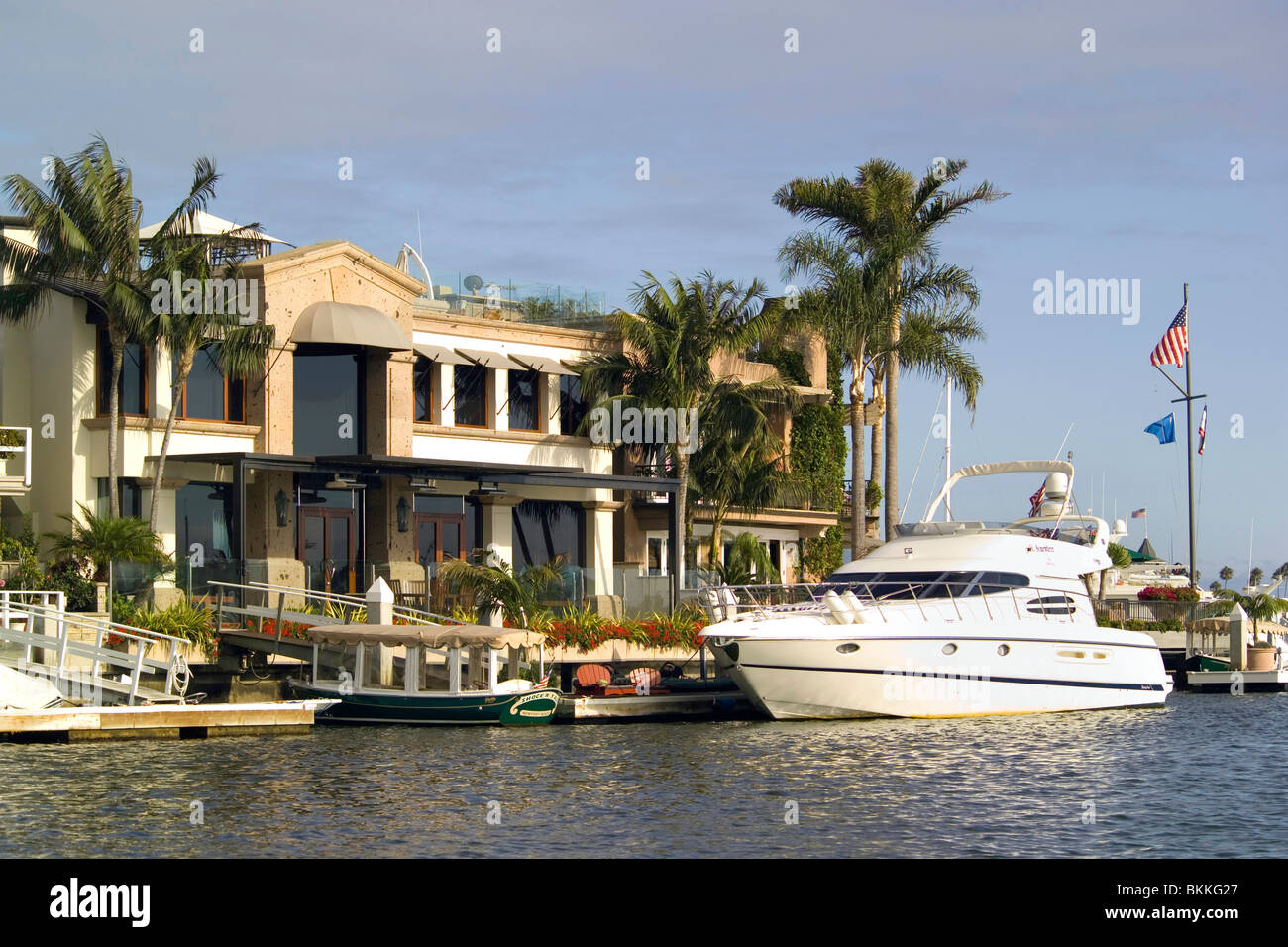 The luxurious yachts and multimillion-dollar waterfront homes of wealthy residents line Newport Harbor in Newport Beach, Southern California, USA. Stock Photo