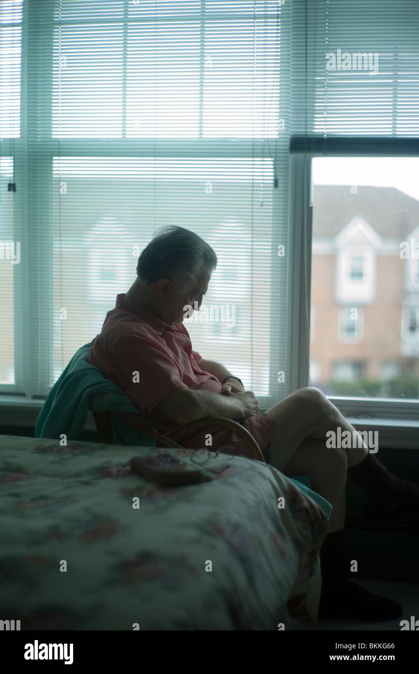 Old man sleeps sitting up in chair by bedroom window Stock Photo Alamy