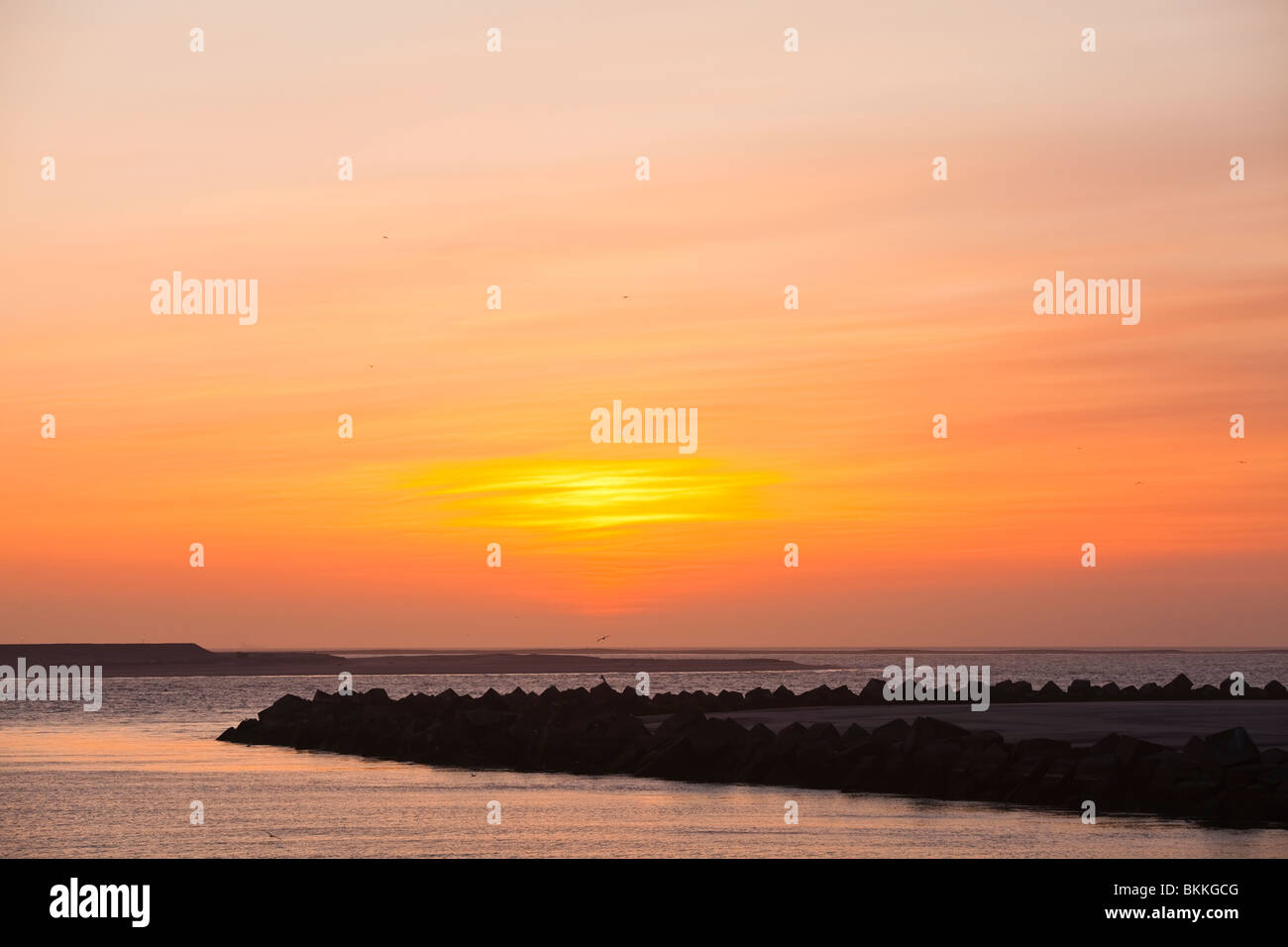 Orange volcanic dust sunset at Dutch coastal area Stock Photo