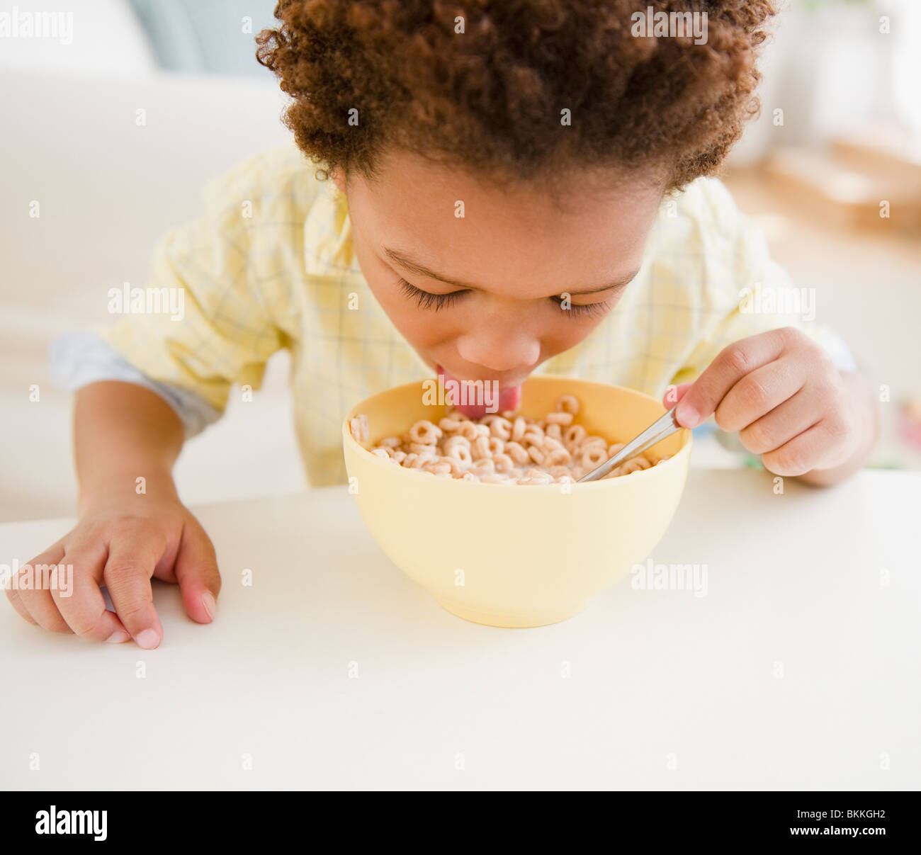 Black boy eating bowl of cereal Stock Photo