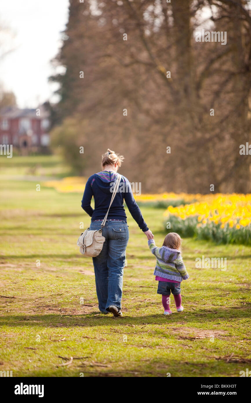 adult woman with young girl walking in a public park Stock Photo