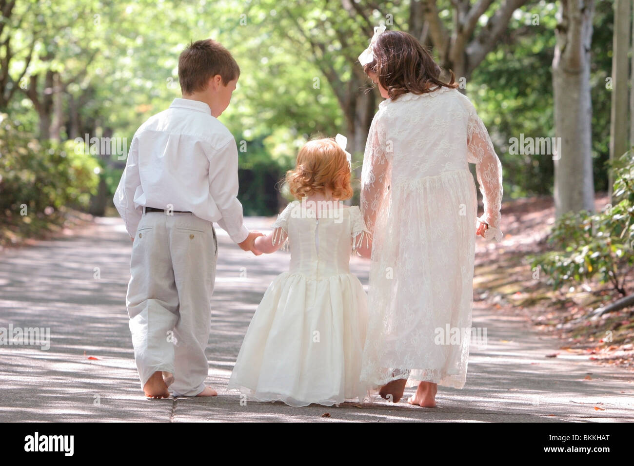 Three Siblings Walking And Holding Hands Stock Photo - Alamy