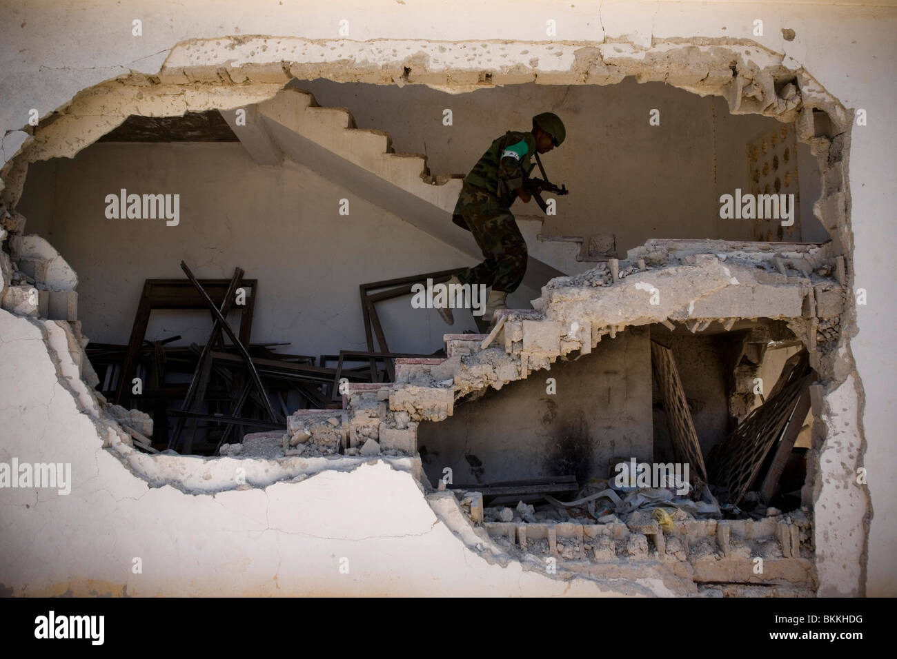 An Africa Union (AU) peacekeeper soldier patrols a destroyed building in the AU military base that was hit by a suicide bomber. Stock Photo