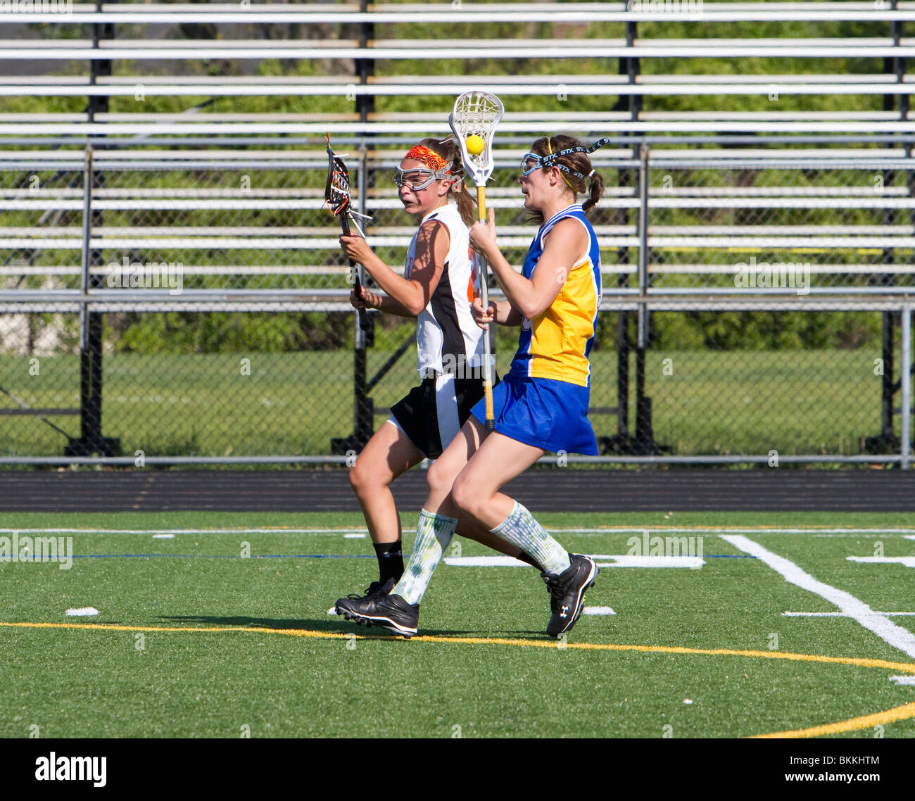 Girls high school lacrosse game. Face off running passing blocking. Teenage girls sports. Stock Photo