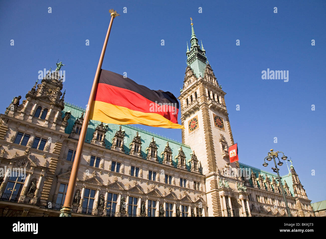 The German flag flies at half-mast in front of the Hamburger Rathaus (Hamburg Town Hall) in Hamburg, Germany. Stock Photo