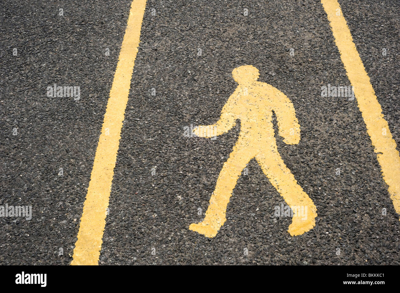 Yellow Pedestrian Walkway Sign painted on a Tarmac Road Surface in a