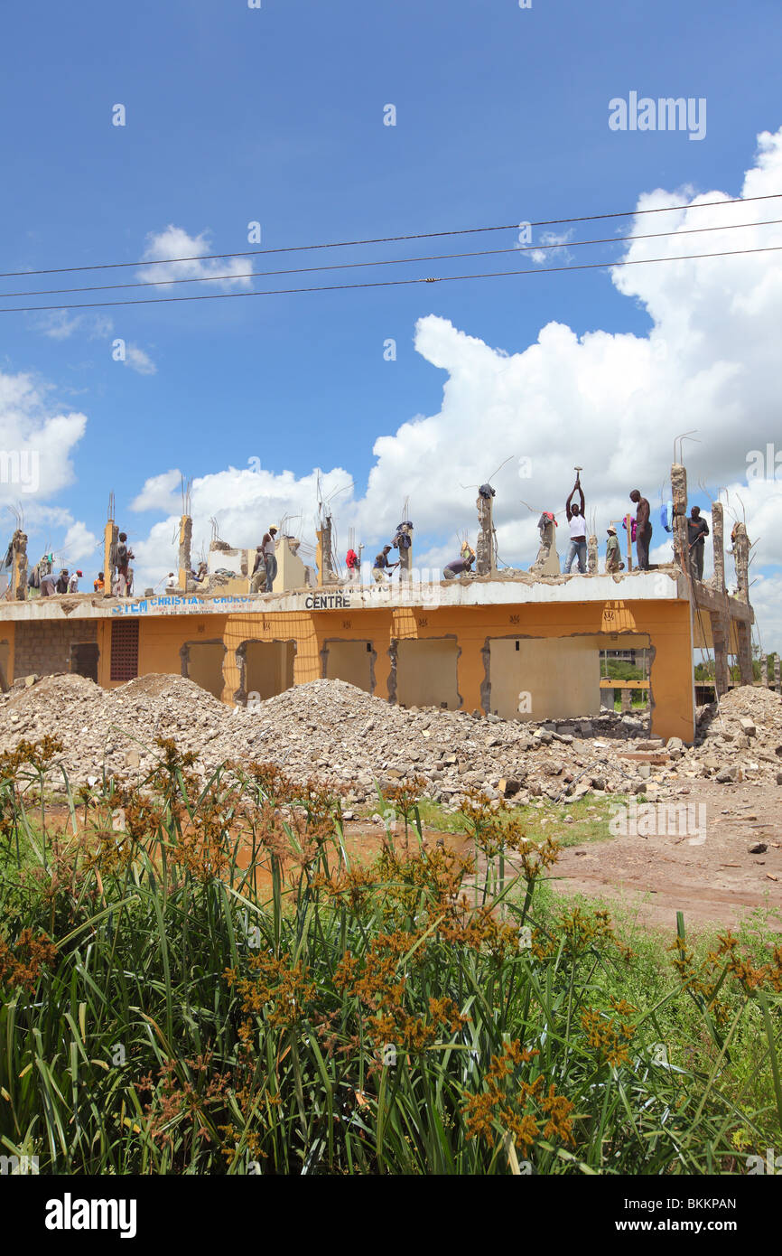 Kenya, wrecking building by hand with hammer, man demolish construction Stock Photo