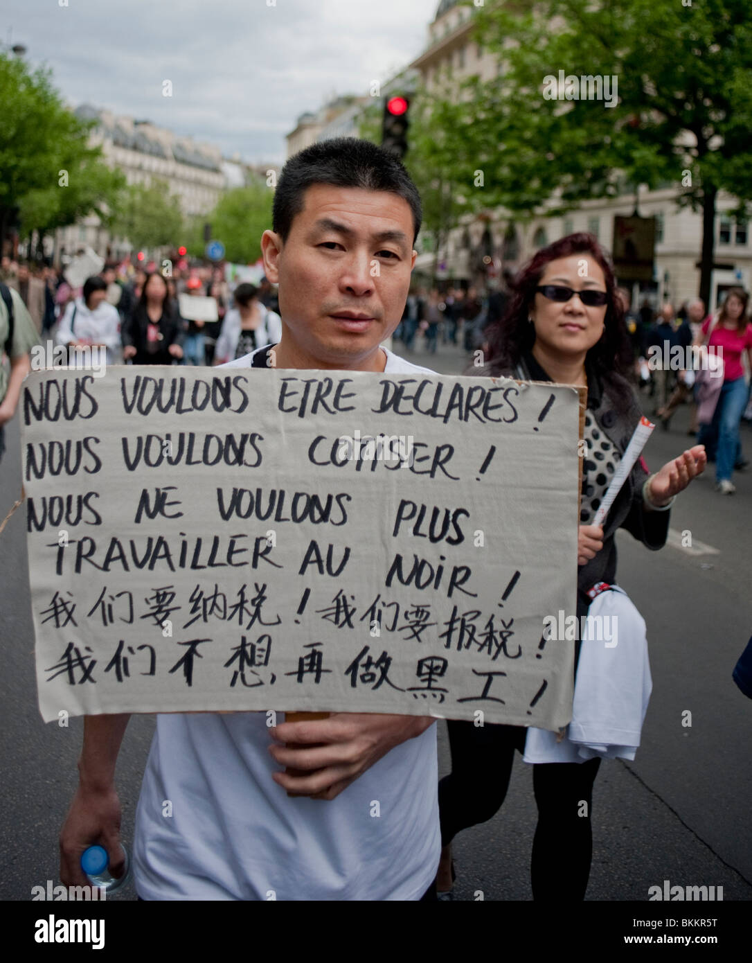 Chinese People Demonstrating in May 1, May Day Demonstration, Paris, France, Portrait, Man Holding Bi-Lingual Protest Sign in Mandarin "Sans papiers" labour workers rights protests, immigrants rights, peaceful protest sign, illegal migrants Euorpe Stock Photo