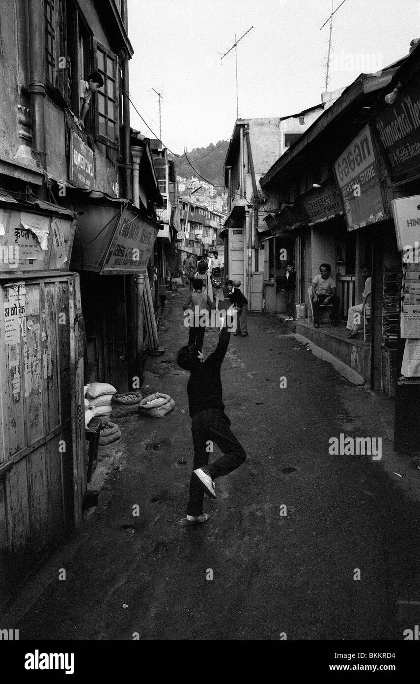 Young boys playing a game of cricket in a narrow street of Sabzi Mandi, the Lower bazar in Shimla Stock Photo