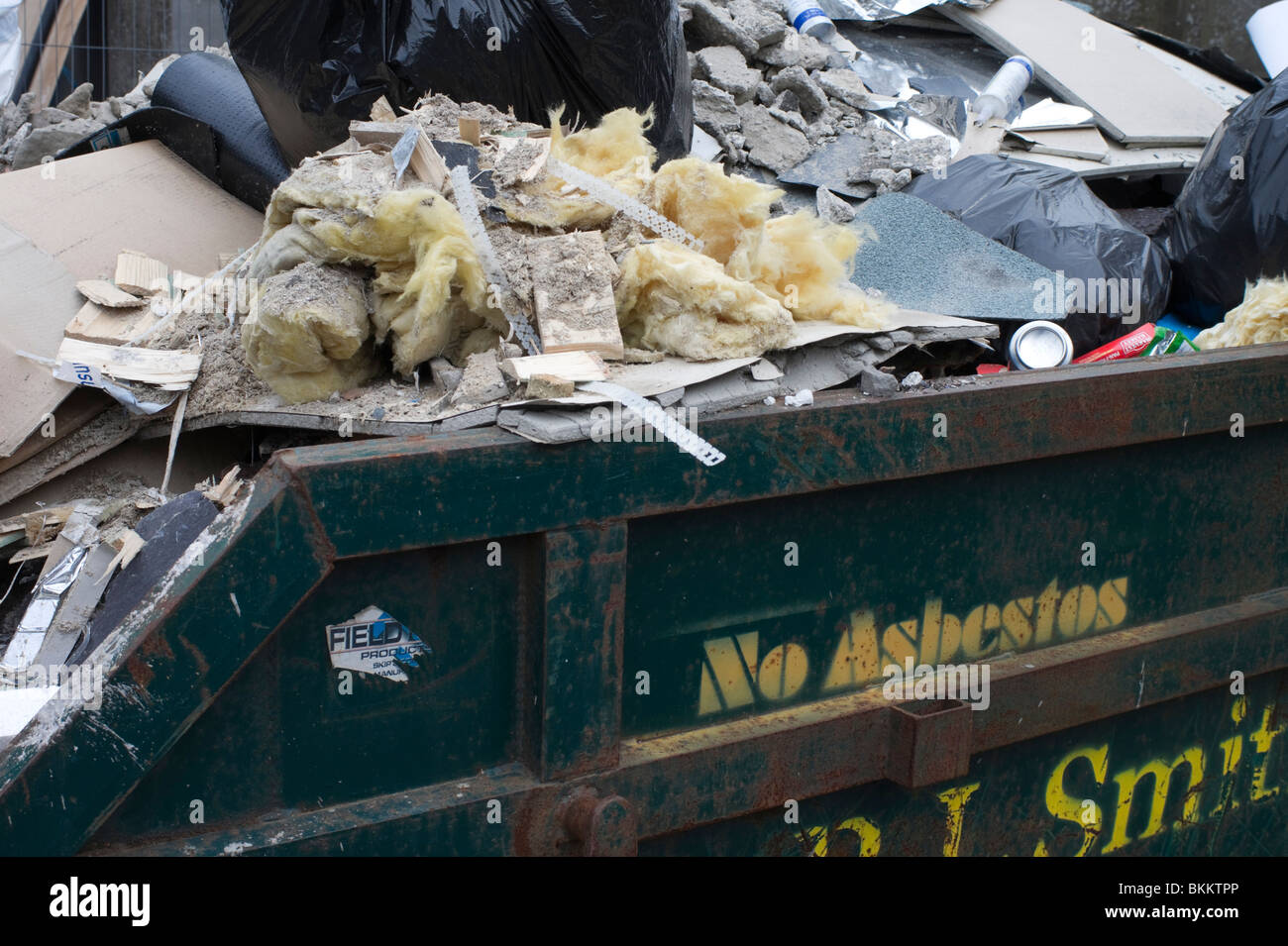 Building work waste in a skip awaiting removal, with NO ASBESTOS sign on the skip - UK Europe Stock Photo