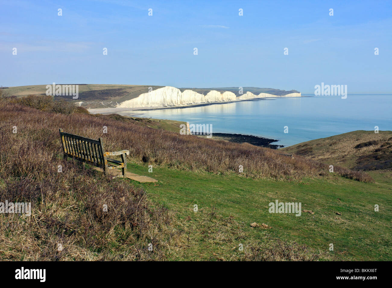 Bench on Seaford Head over looking Cuckmere Haven and the chalk cliffs of the Seven Sisters, East Sussex England UK Stock Photo