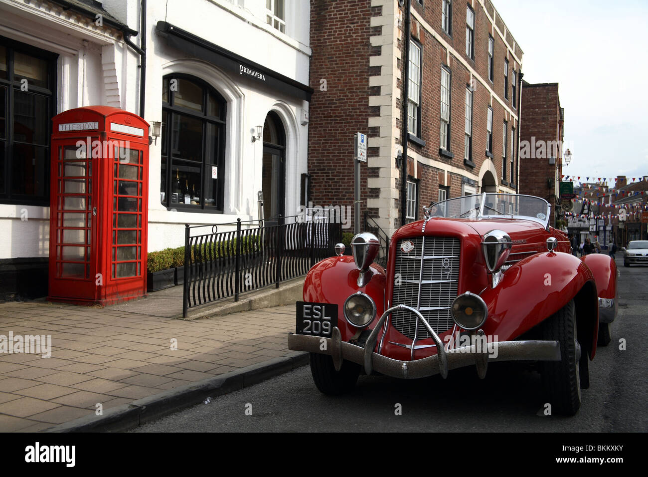 Classic car and red phone box  in the town of Knutsford Cheshire UK Stock Photo
