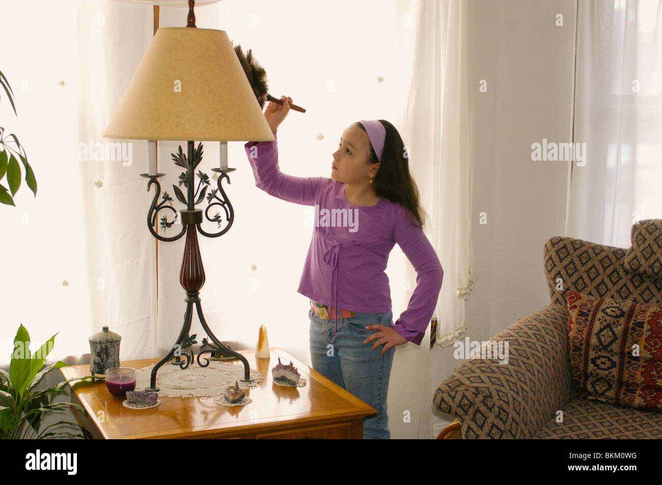 8 year old Hispanic girl cleaning house. Stock Photo