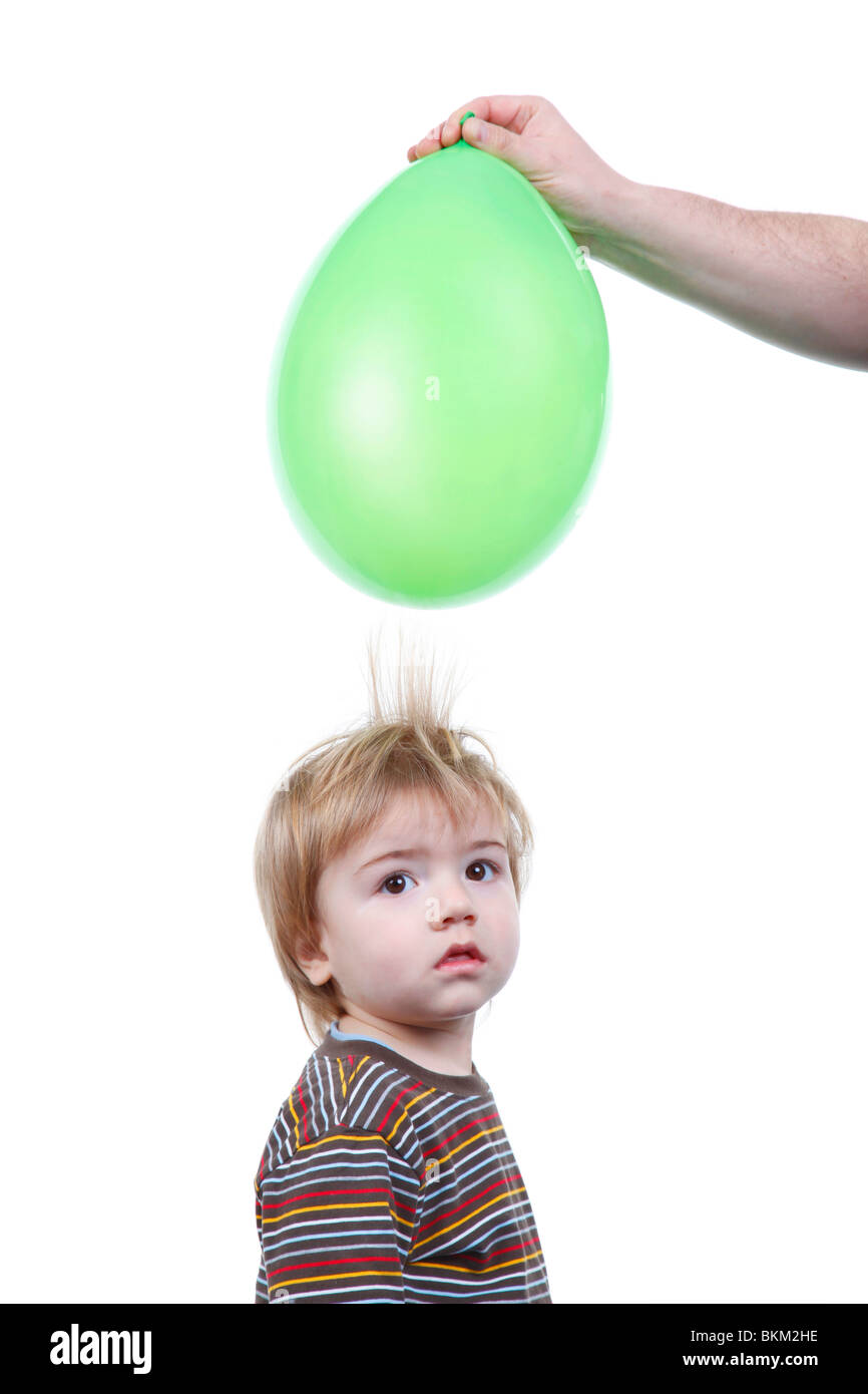 little boy's hair being attracted by an air balloon charged with static