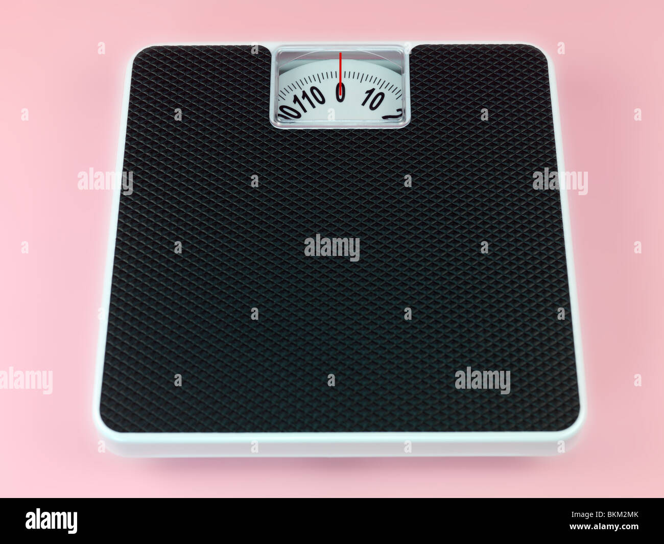 A set of bathroom scales isolated against a pink background Stock Photo