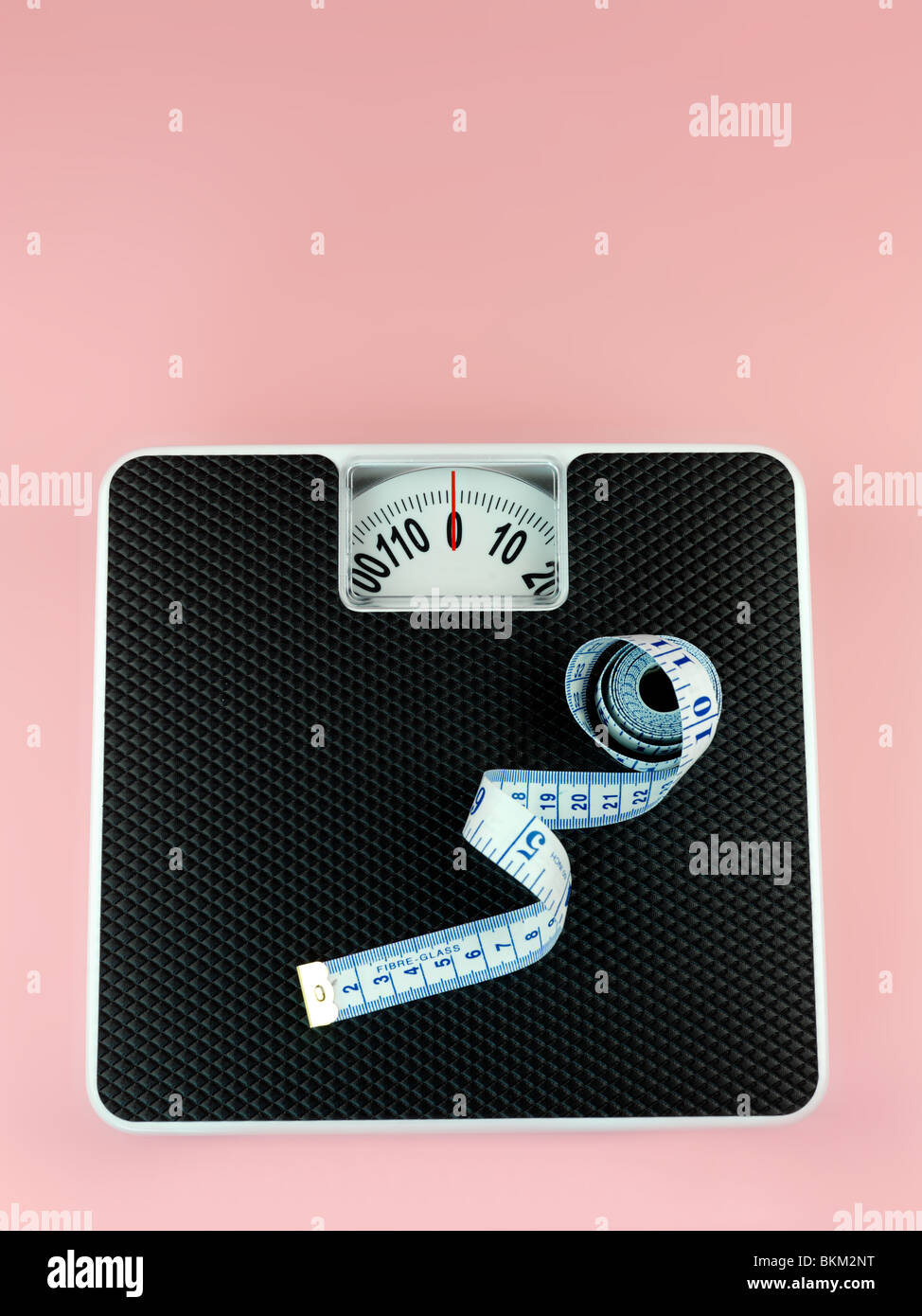 A set of bathroom scales isolated against a pink background Stock Photo