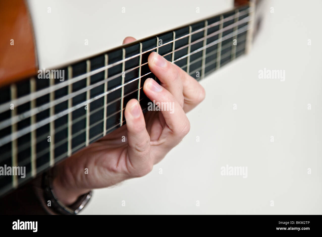 Nylon string classical guitar close up with left hand fingering the chord E7 b9 Stock Photo
