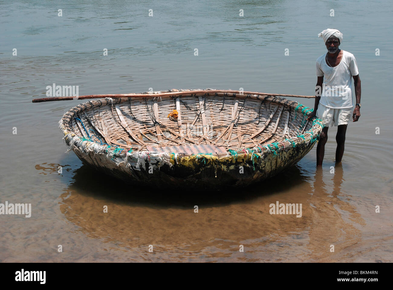 A boat man using circular basket boat ; india Stock Photo Alamy