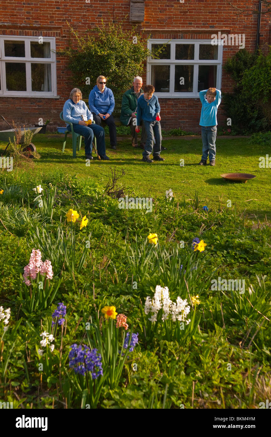 A MODEL RELEASED picture of a family playing garden boules in an English country cottage garden in Suffolk , England , Uk Stock Photo