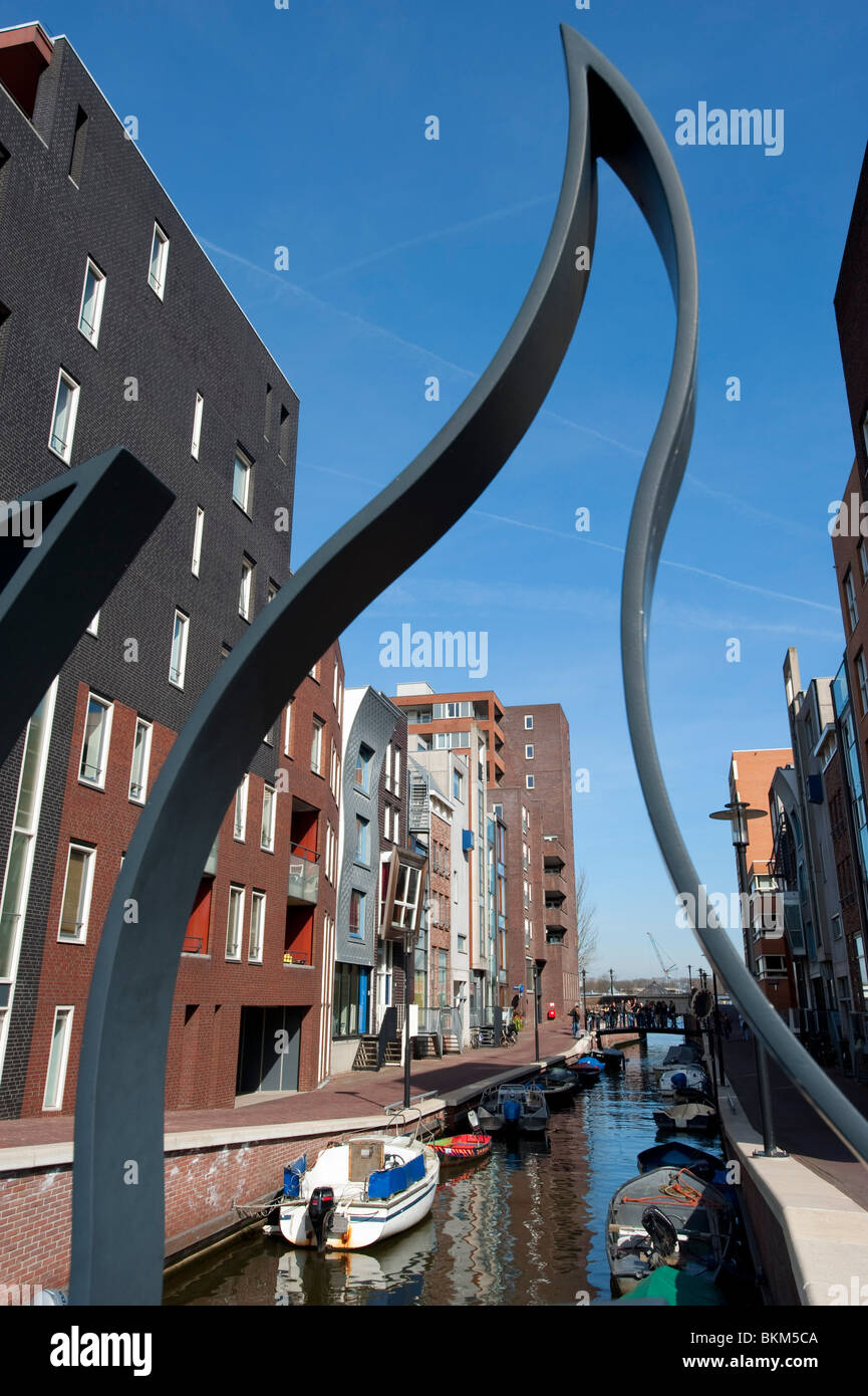 View from ornate footbridge of modern apartment buildings and canal in Java Island district of Amsterdam The Netherlands Stock Photo