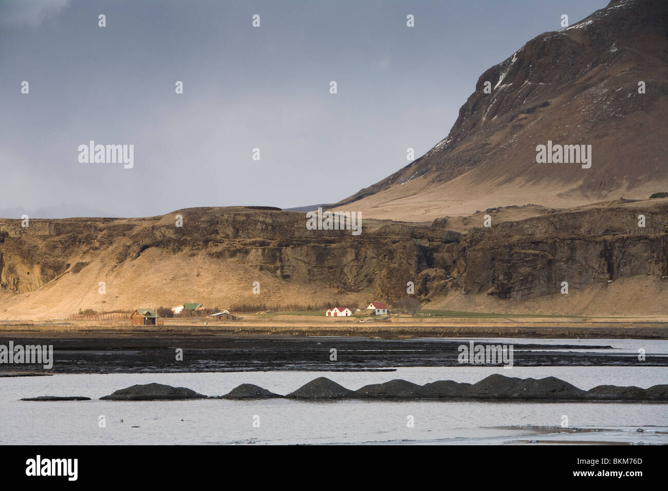 Houses next to Markarfljot glacial river which flooded during the volcanic eruption in Eyjafjallajokull glacier, South Iceland. Stock Photo
