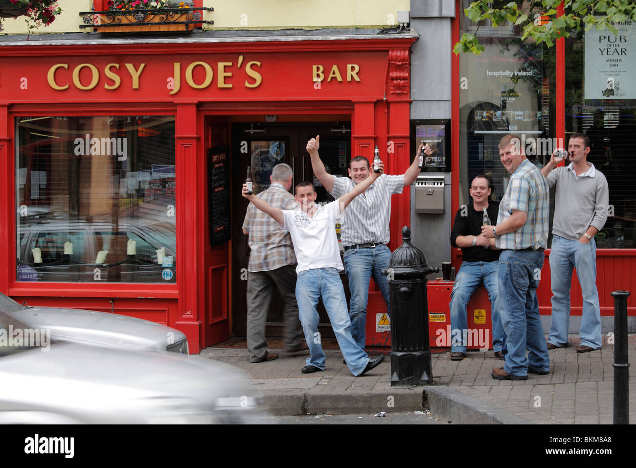 beer drinking fans of Gaelic football in front of Cosy Joe's Bar in Westport Stock Photo