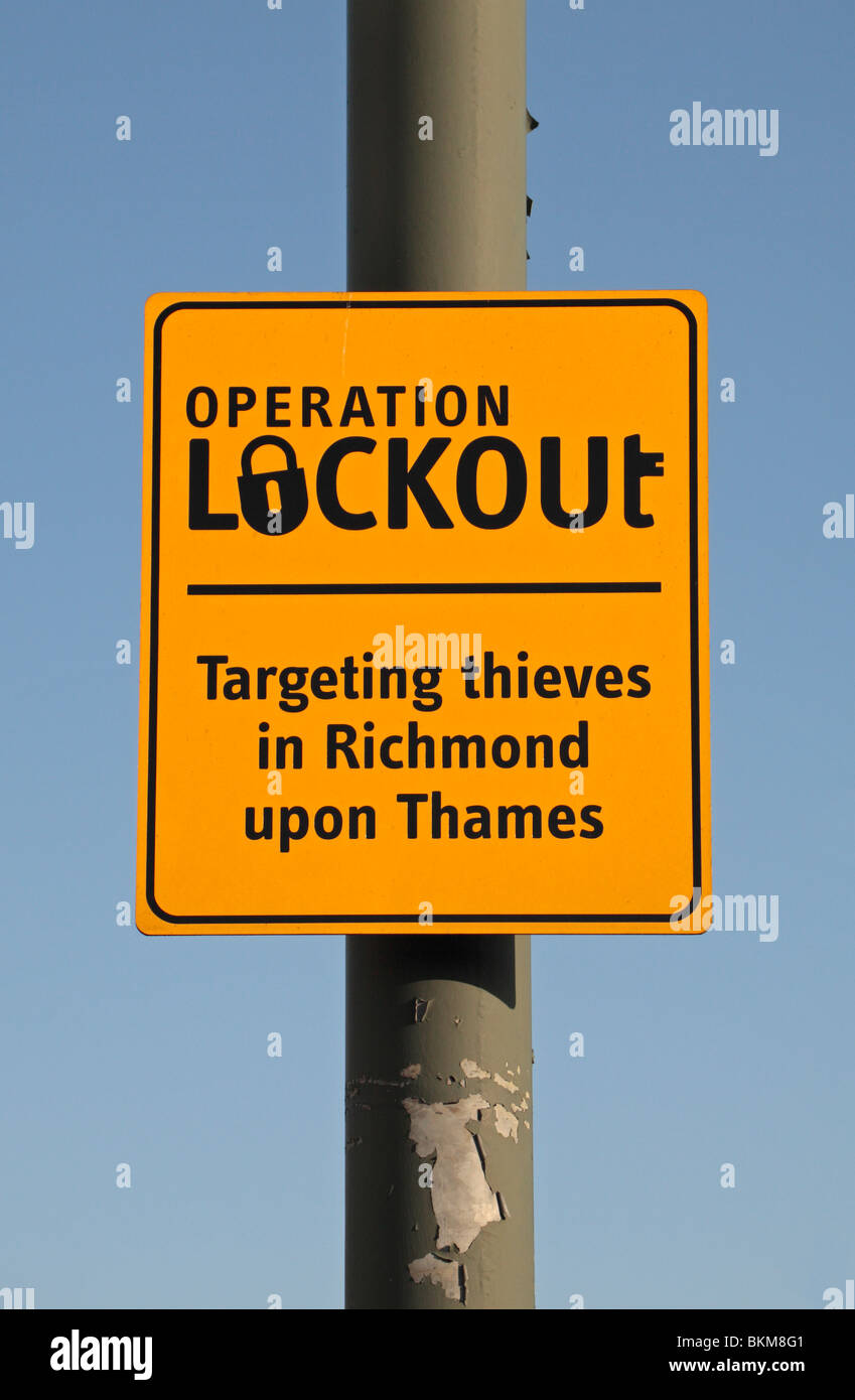 A yellow sign warning residents of Richmond upon Thames, UK, about theives targeting vehicles. Stock Photo