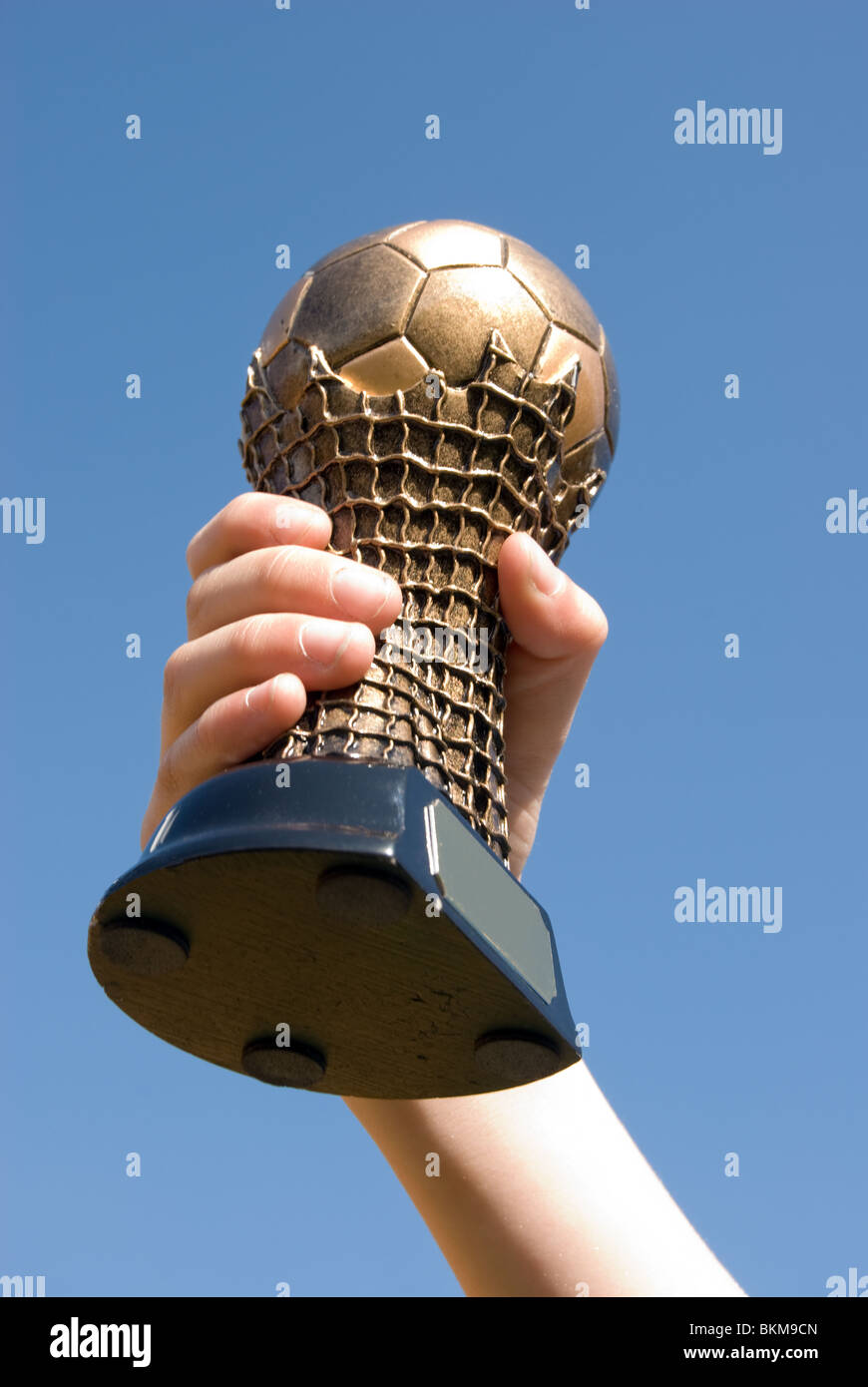 Boys hand holding a football trophy Stock Photo Alamy